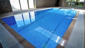 A clear indoor swimming pool with tiled edges and a drain in the center. - El Castillo (Larraga)