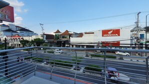 A commercial area with a Honda dealership, a restaurant, and a pedestrian walkway. - Rene Hotel (Yogyakarta)