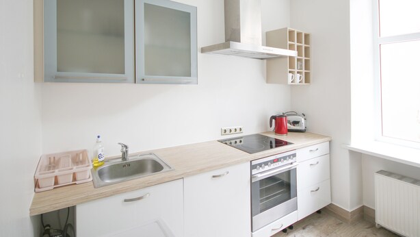Una cocina con un lavabo, estufa y armarios.