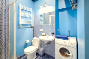 Ein Badezimmer mit Toilette, Waschbecken und Waschmaschine.