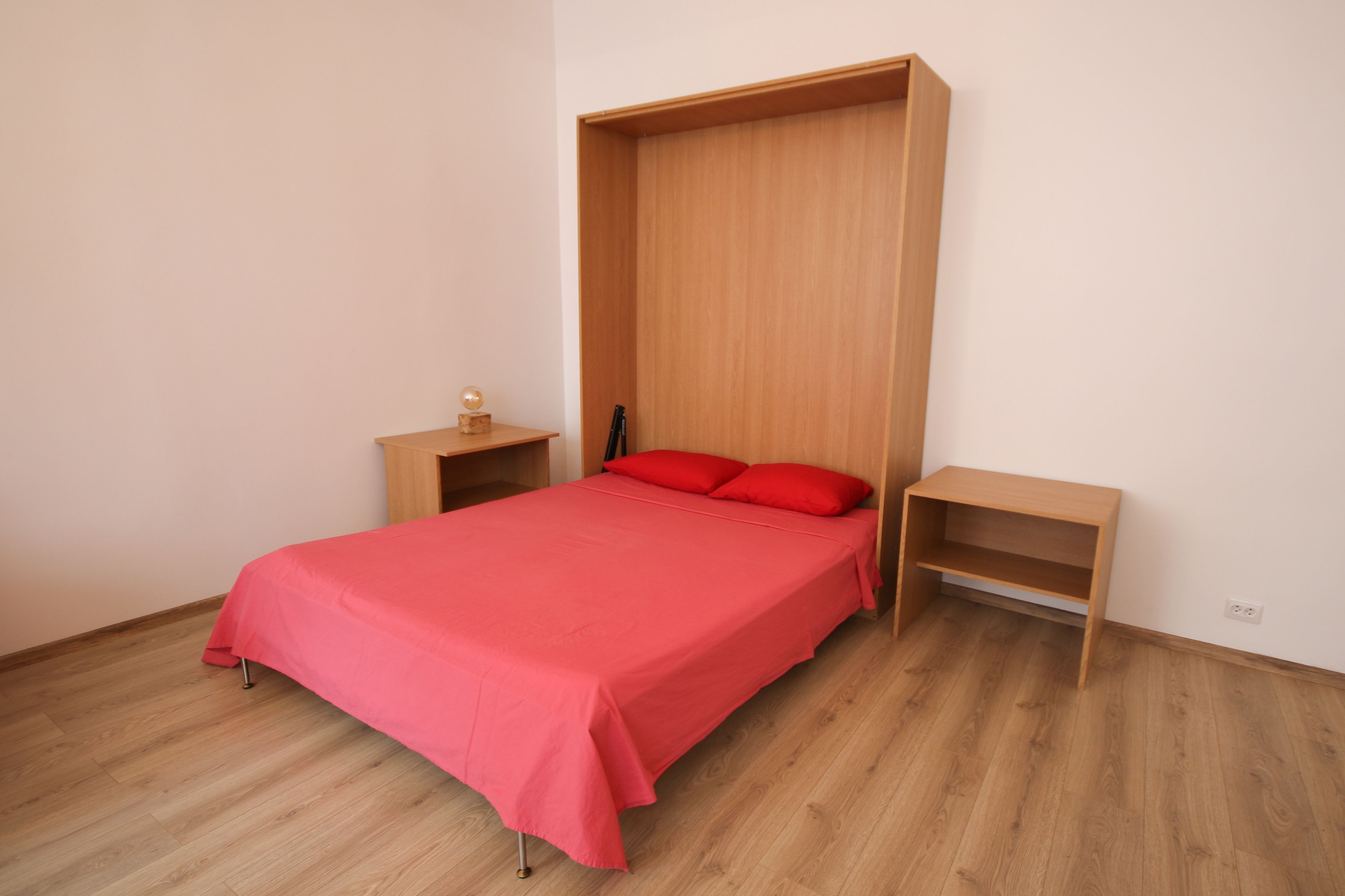 Ein Schlafzimmer mit einem Bett, einem Nachttisch und einem Holzregal.