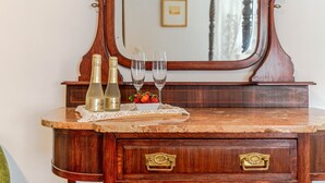 Een houten dressoir met twee flessen en twee glaasjes op een marmeren blad.