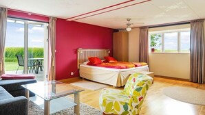 A bedroom with a bed, a chair, a table, and a view of the outdoors. - Hotel Borrby (Borrby)