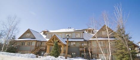 A large, multi-story lodge with a snow-covered roof and a prominent front entrance.