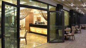 Un vestíbulo de hotel moderno con mostrador de recepción, zona de estar y ventanas amplias.