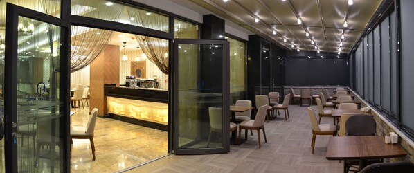 Un hall d’hôtel moderne avec un comptoir d’accueil, un espace salon et de grandes fenêtres.