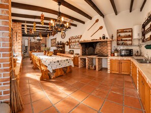 A rustic kitchen with a brick oven, wooden furniture, and a tiled floor. - Vila Louro (Torres Vedras)