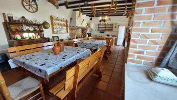A rustic dining area with wooden benches and a table covered with a patterned tablecloth.