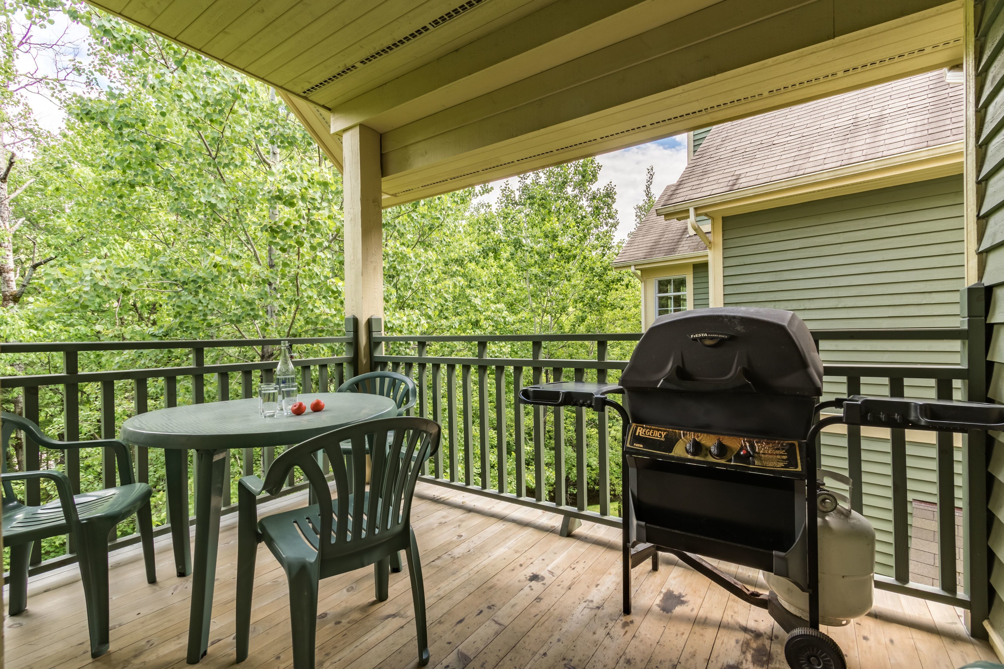 Eine Terrassengruppe mit Grill, rundem Tisch und Stühlen.