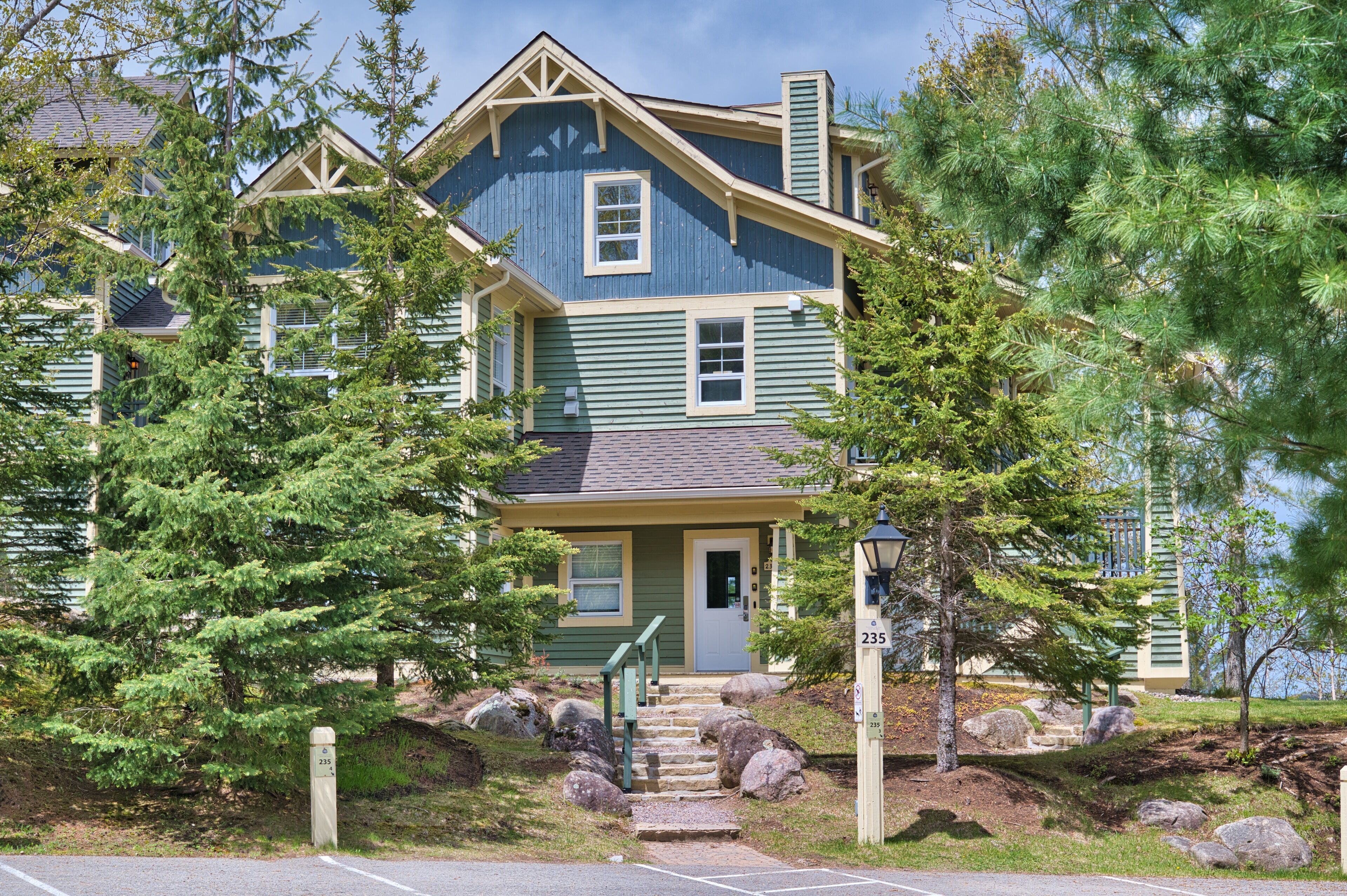 A two-story building with a front entrance, a staircase, and a small porch area.