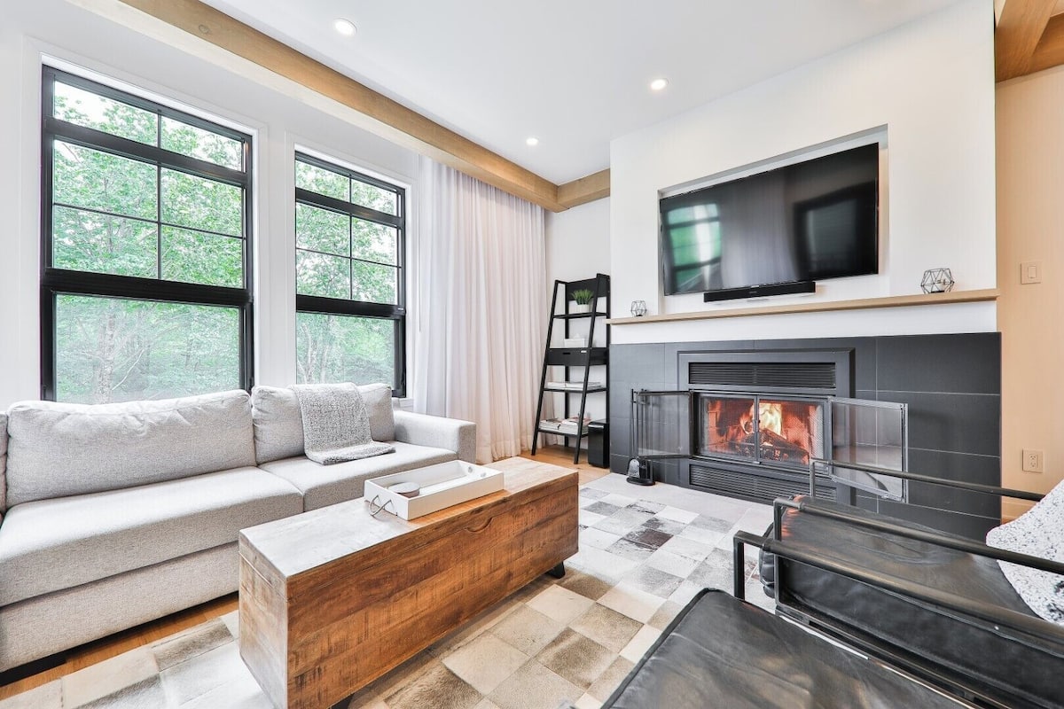Una sala de estar moderna con chimenea, un sofá y una mesa de centro.