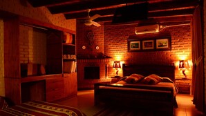 Ein gemütliches Zimmer mit Backsteinwand, einem Bett, einem Kleiderschrank und einem Deckenventilator.
