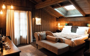 A cozy bedroom with a bed, a sofa, and a skylight. - Chalet Hotel le Castel (Chamonix-Mont-Blanc)