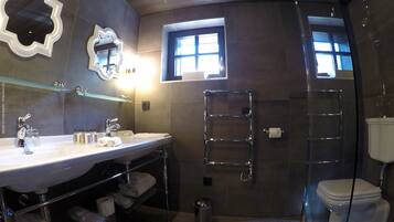 A modern bathroom with a large vanity, a glass shower enclosure, and a toilet.
