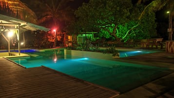 Una piscina al aire libre, sillones reclinables de piscina