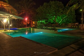 Una piscina al aire libre, sillones reclinables de piscina