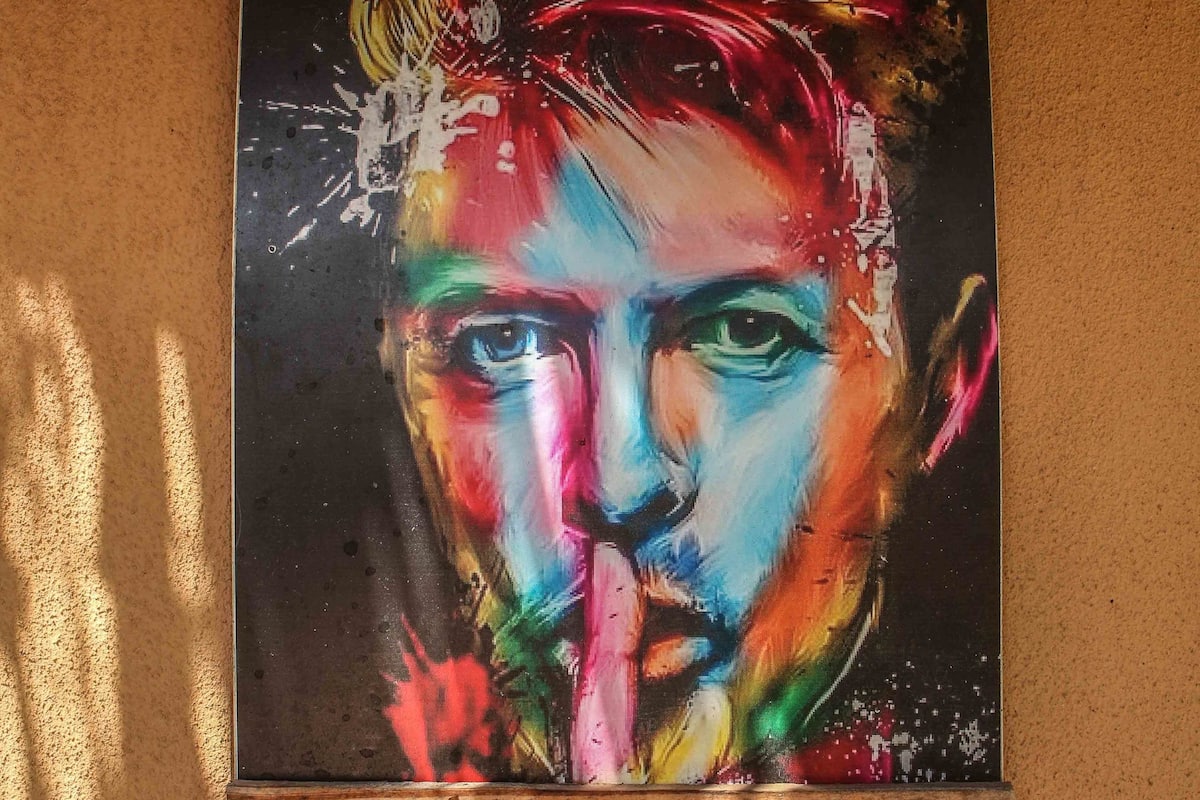 A colorful painting on a textured wall.