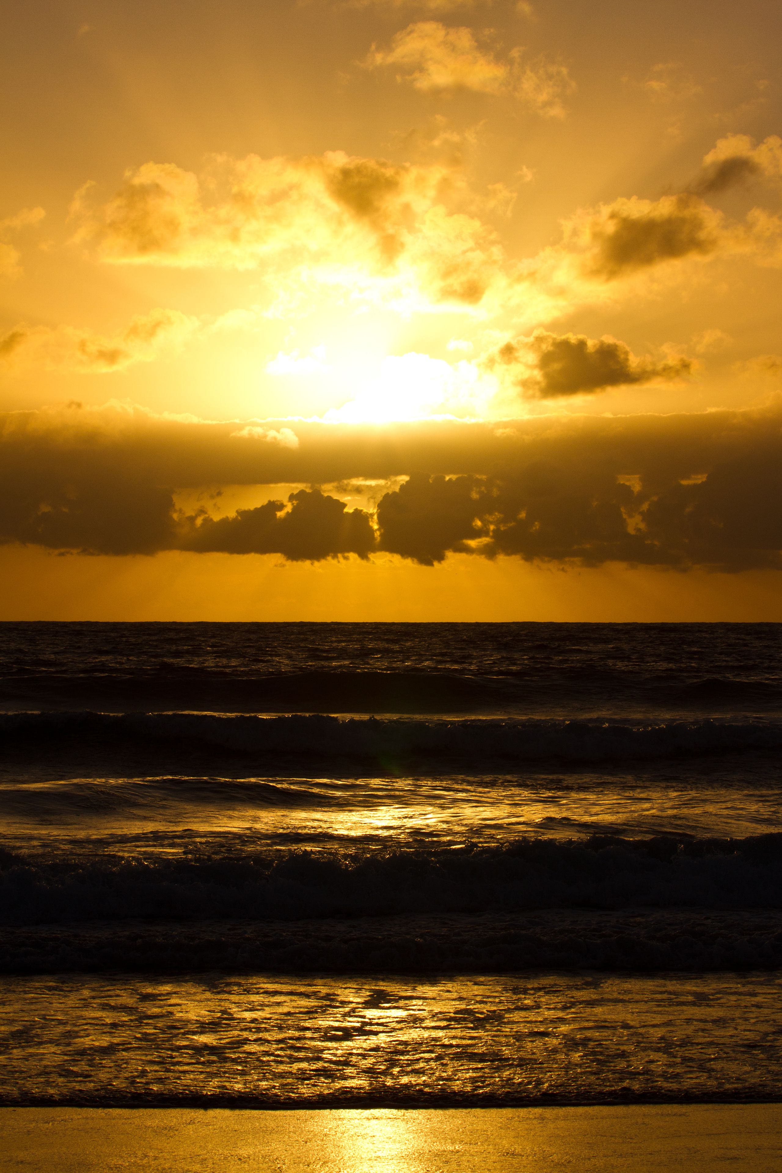 A sunset over the ocean with waves.