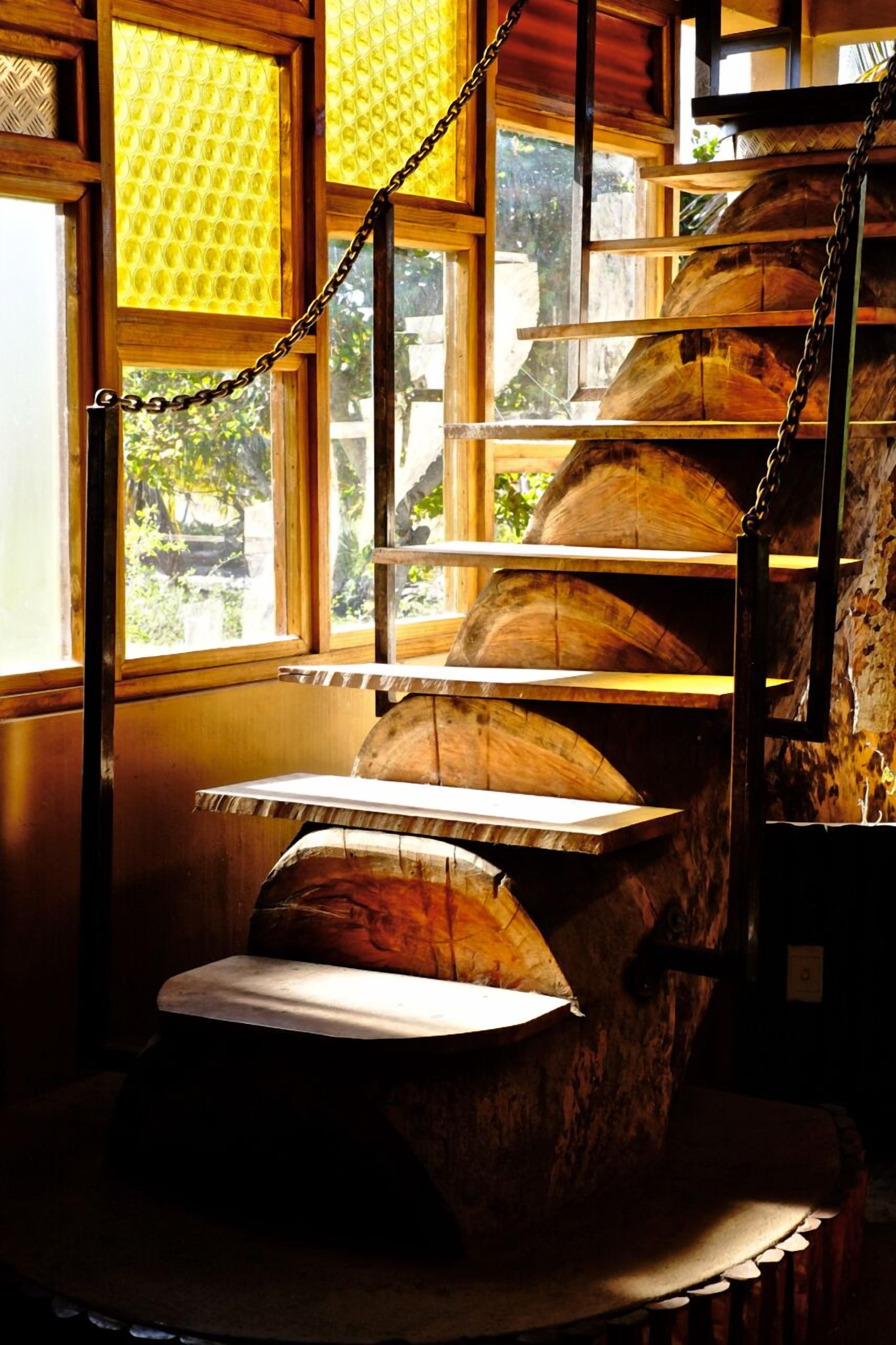 A rustic interior with wooden shelves and a staircase.