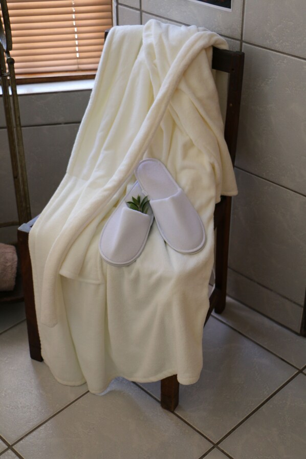 Une chaise avec une serviette blanche et des chaussons.