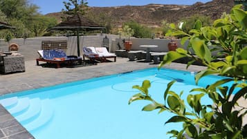 Een buitenzwembad en parasols bij het zwembad