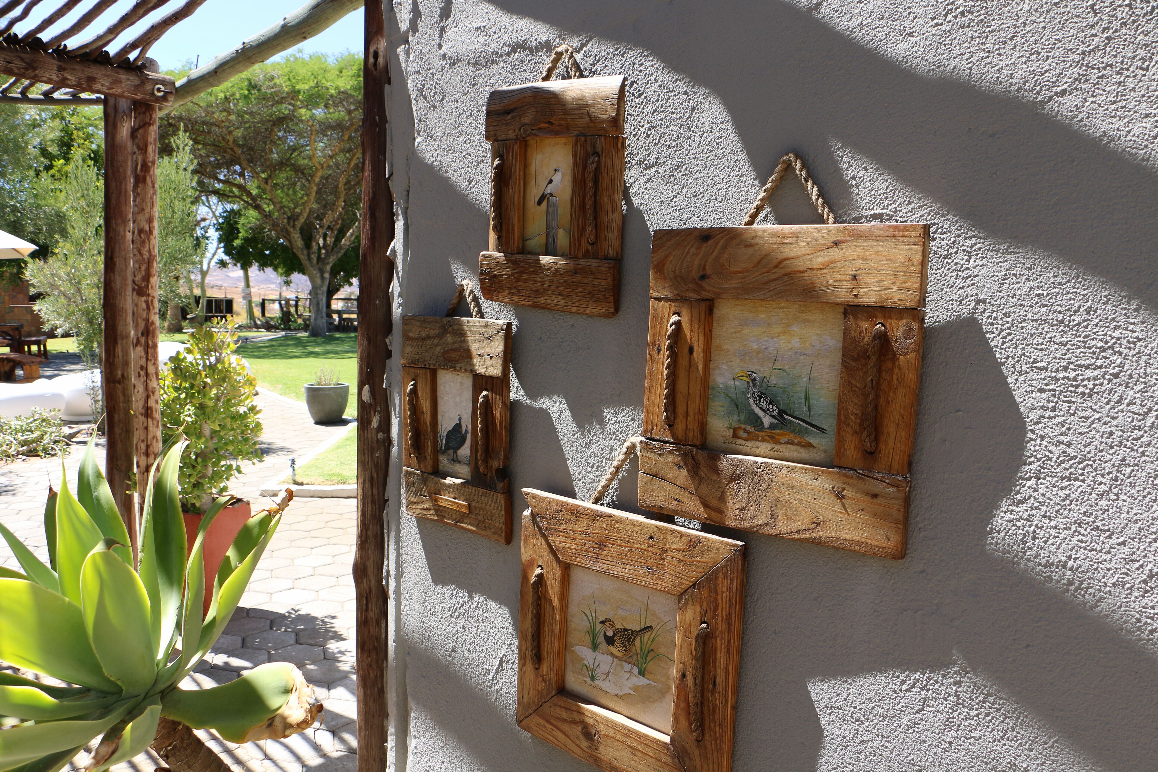 Cuadros de madera con pinturas de pájaros en una pared.