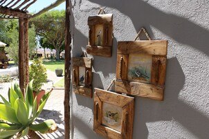 Cuadros de madera con pinturas de pájaros en una pared.
