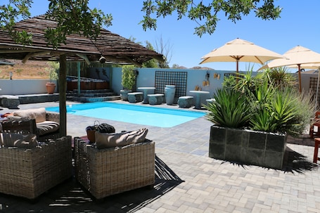 Una piscina al aire libre, sombrillas
