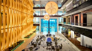 A spacious lobby with a modern design, featuring a central seating area, a large glass entrance, and a high ceiling with hanging spherical light fixtures. - Grand Hyatt Abu Dhabi Hotel & Residences (Abu Dhabi)