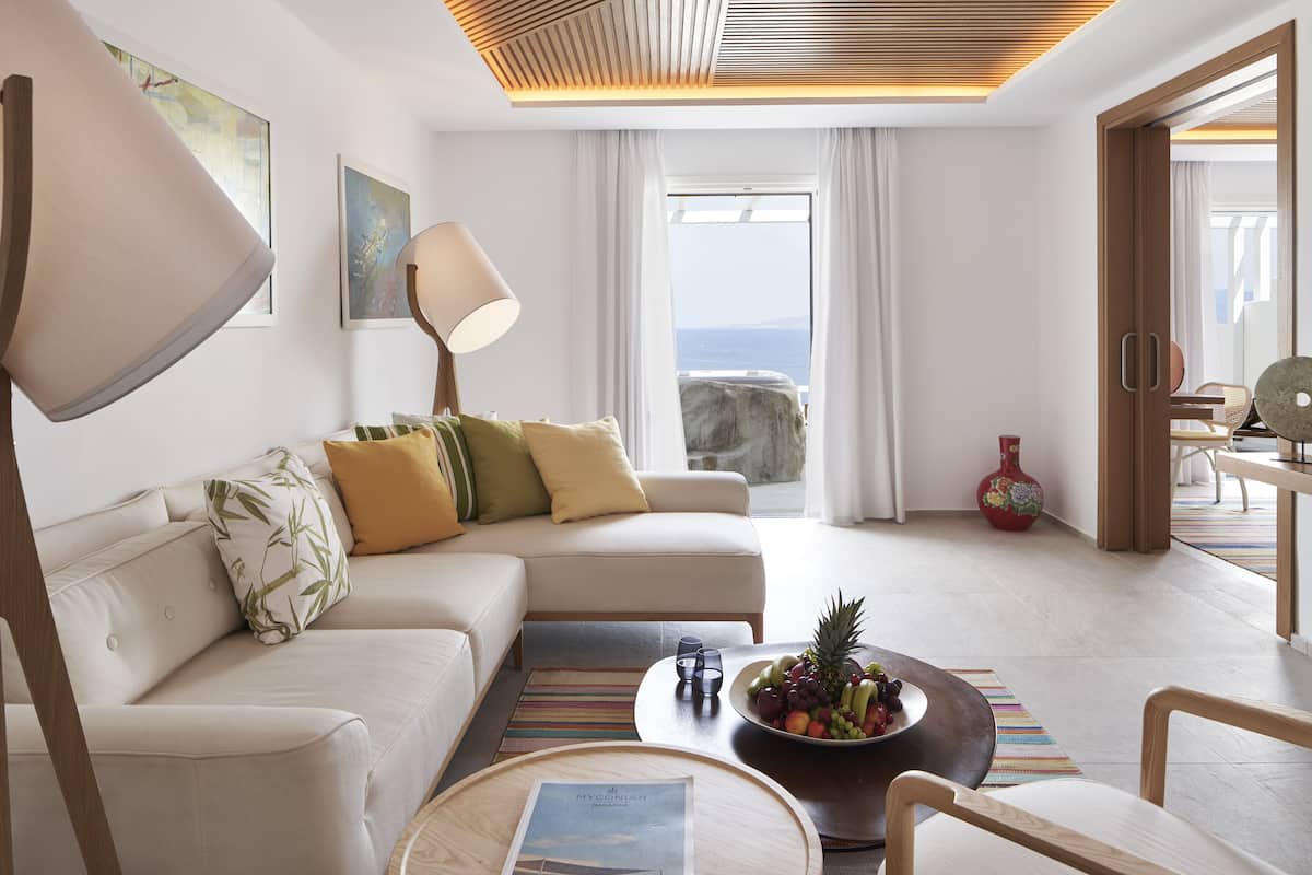 Ein modernes Wohnzimmer mit einer Couch, einem Couchtisch und Blick auf das Meer.