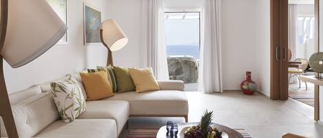 Ein modernes Wohnzimmer mit einer Couch, einem Couchtisch und Blick auf das Meer.