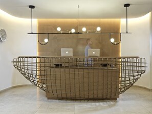 A reception desk with a modern design, featuring a metal grid structure and two laptops on it.