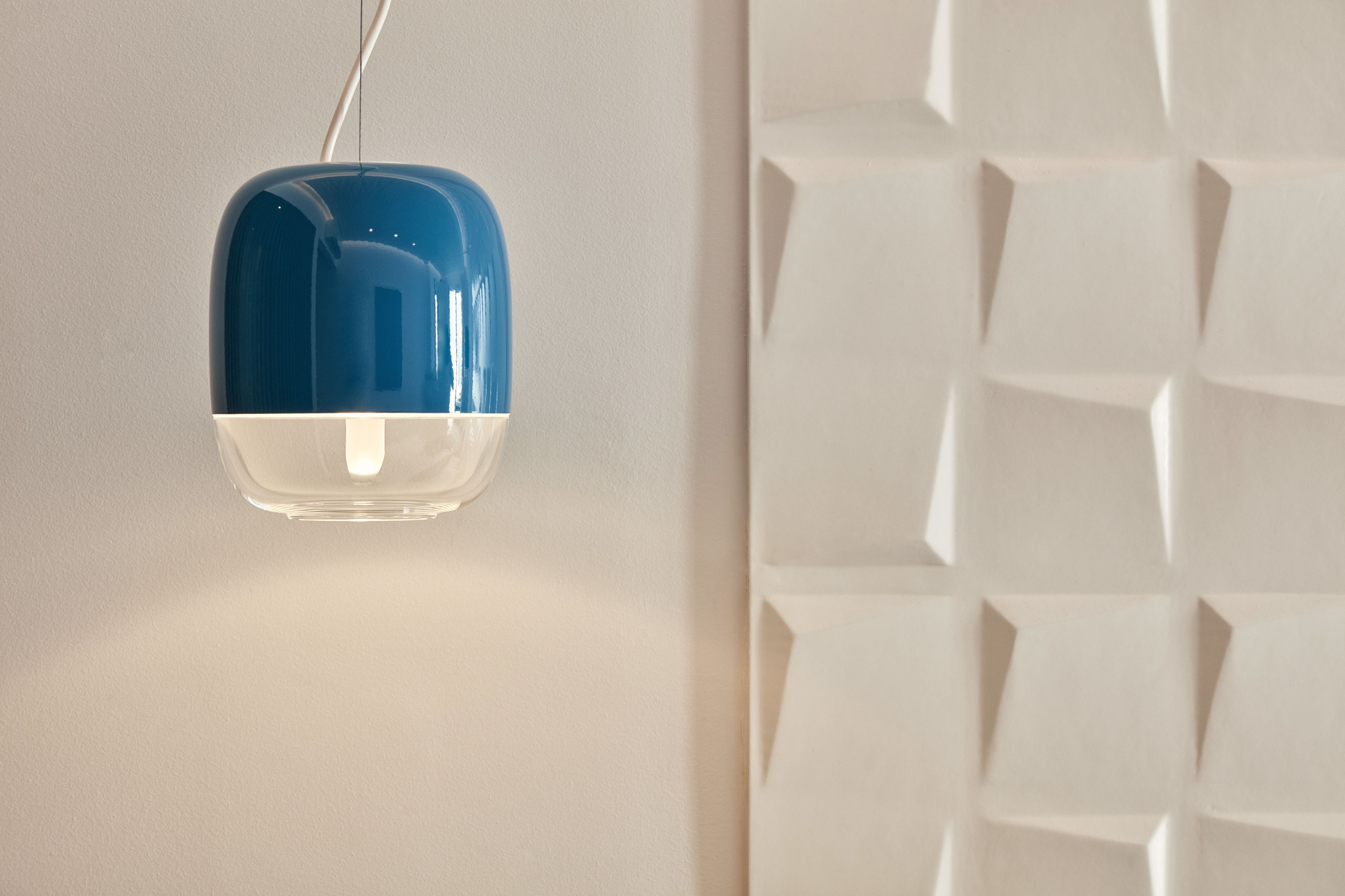 Una lámpara colgante moderna con diseño azul y blanco, suspendida del techo.