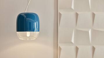 Una lámpara colgante moderna con diseño azul y blanco, suspendida del techo.
