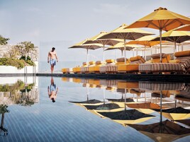 Una piscina al aire libre de temporada, sombrillas