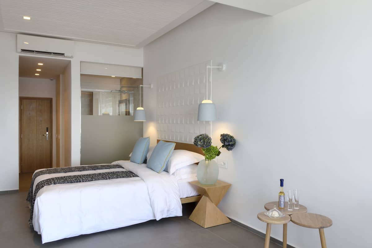 Ein modernes Schlafzimmer mit Bett, Nachttischen, einem Spiegel und einer Wandleuchte.