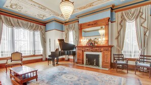 A grand room with a grand piano, ornate fireplace, and elegant furniture. - The Gables at Stirling Guest Hotel (Reading)