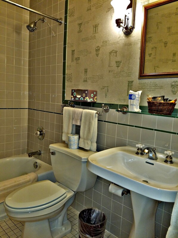 A bathroom with a bathtub, toilet, and sink.