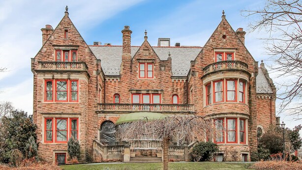 A large, historic stone building with multiple towers and red-framed windows. - The Gables at Stirling Guest Hotel (Reading)