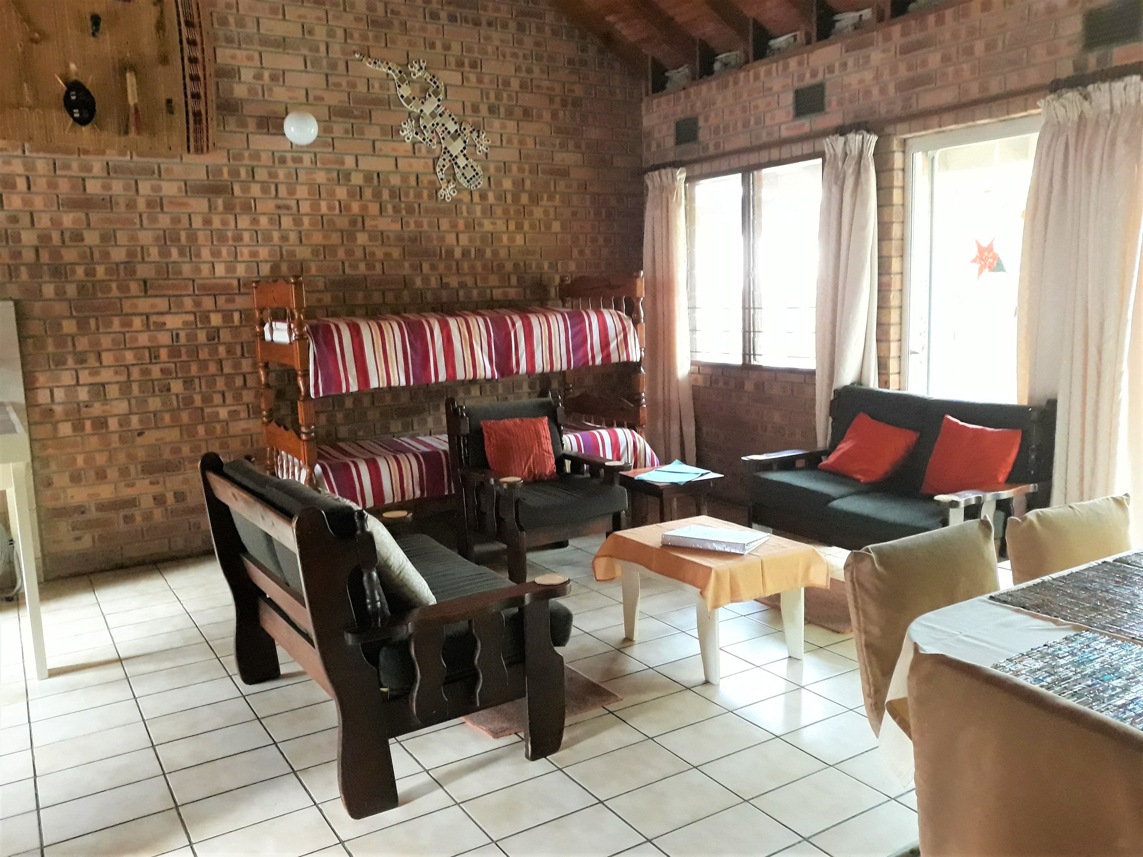 A cozy living room with a brick wall, a sofa set, a wooden bench, and a coffee table.