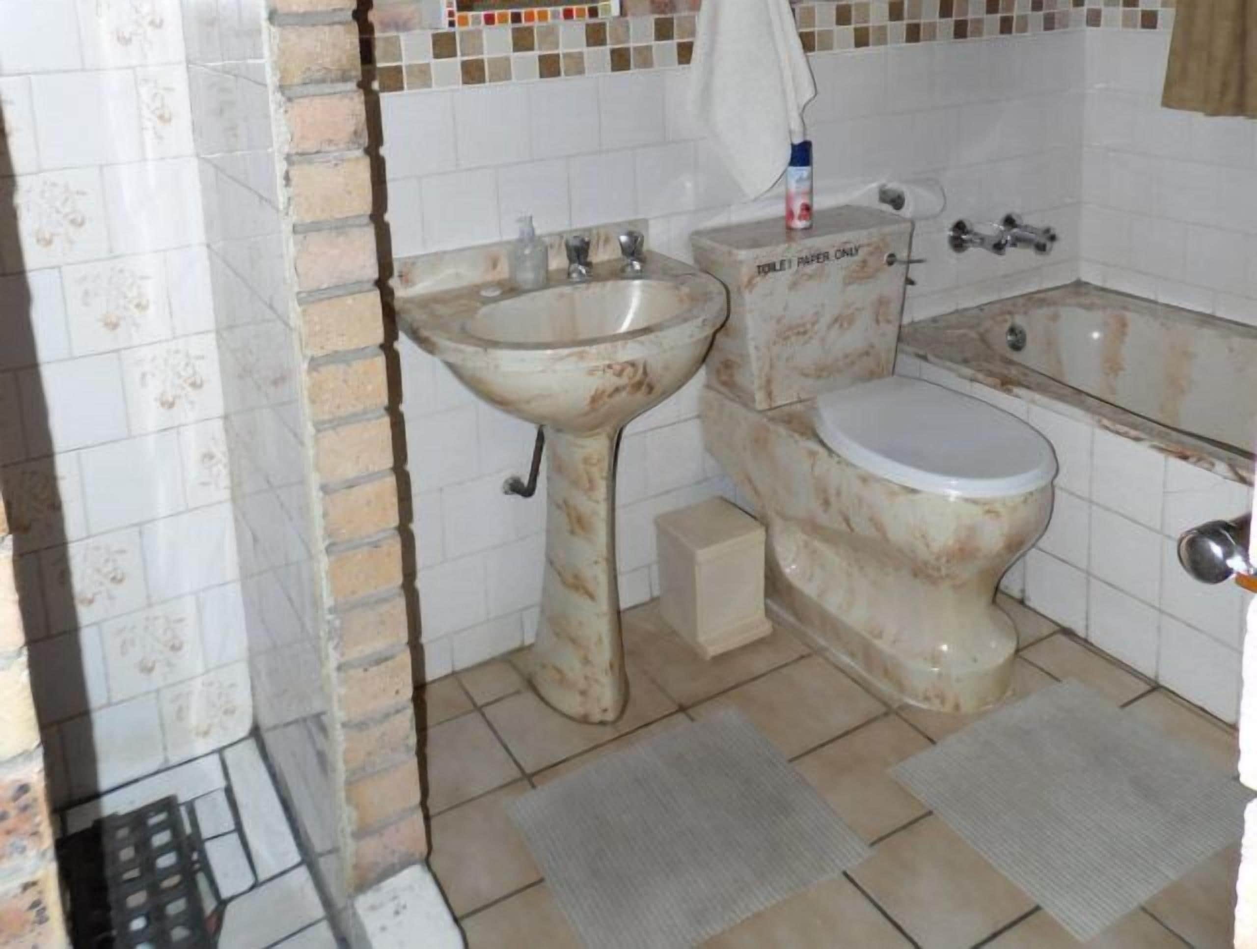 Kylpyhuone, jossa on pesuallas, wc ja kylpyamme.