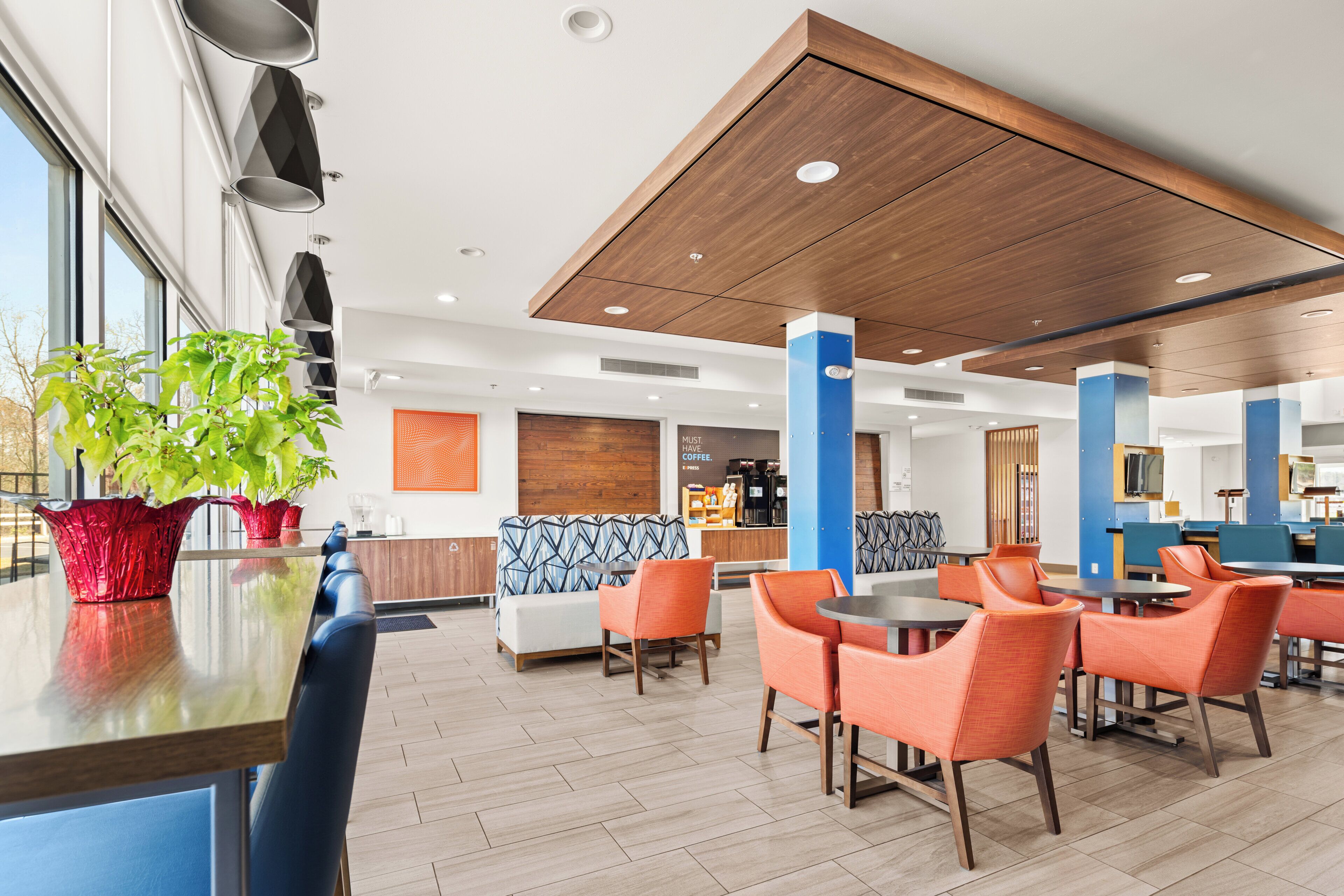 A modern interior with seating areas, a coffee bar, and a large window.
