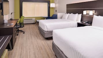 A hotel room with two beds, a desk, a chair, a TV, and a window with blinds.
