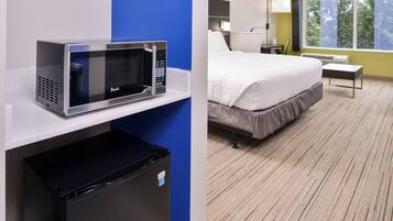 Una kitchenette compacta con microondas, un refrigerador pequeño y un lavamanos.