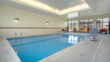 Una piscina techada, sillones reclinables de piscina