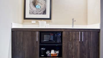 A bathroom with a dark wood vanity, a framed picture of a bird's nest, and a white countertop.