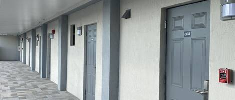 A corridor with grey doors, each marked with a number.