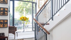 Eine Treppe mit hölzernem Geländer und Metallspindeln, die zu einer oberen Etage führt.