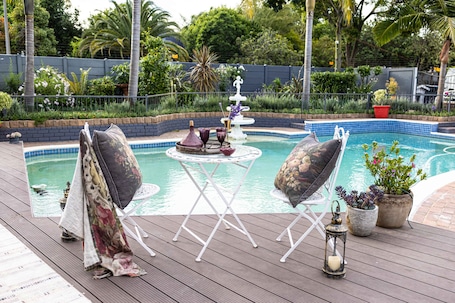 Una piscina al aire libre, sillones reclinables de piscina
