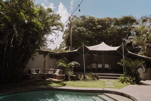 Una piscina al aire libre, sillones reclinables de piscina